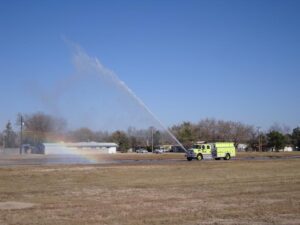 Water spraying from fire truck creating a small rainbow